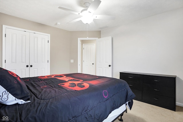 bedroom featuring ceiling fan, a closet, and light carpet