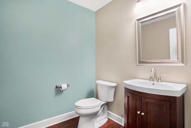 bathroom featuring vanity, toilet, and hardwood / wood-style floors