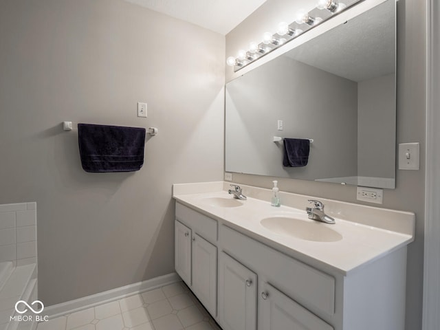 full bath featuring double vanity, a sink, a bathing tub, and baseboards