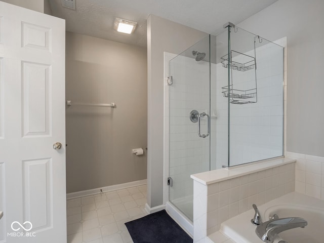 bathroom featuring a stall shower, baseboards, tile patterned floors, a textured ceiling, and a bath