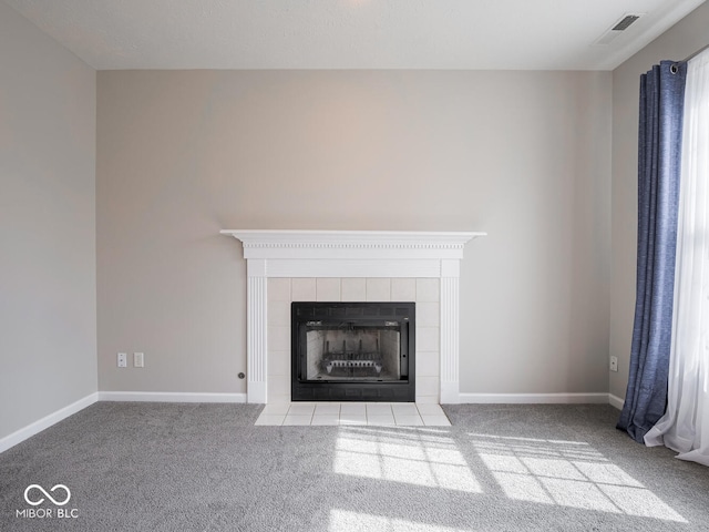 room details featuring carpet floors, baseboards, visible vents, and a tiled fireplace