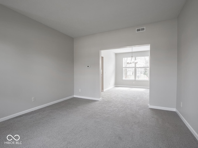 empty room with baseboards, dark carpet, visible vents, and an inviting chandelier