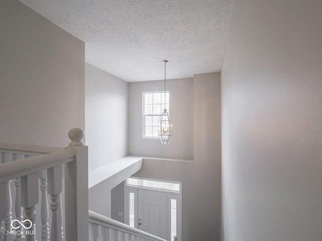 foyer with a chandelier and a textured ceiling