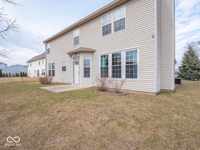 rear view of property featuring a patio, a lawn, and central air condition unit