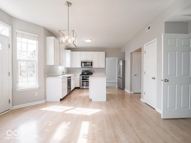 kitchen featuring light wood finished floors, light countertops, visible vents, appliances with stainless steel finishes, and white cabinetry