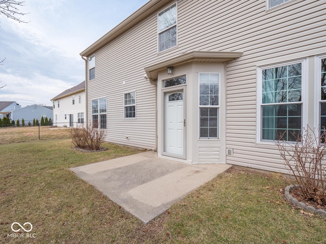 doorway to property with a yard and fence