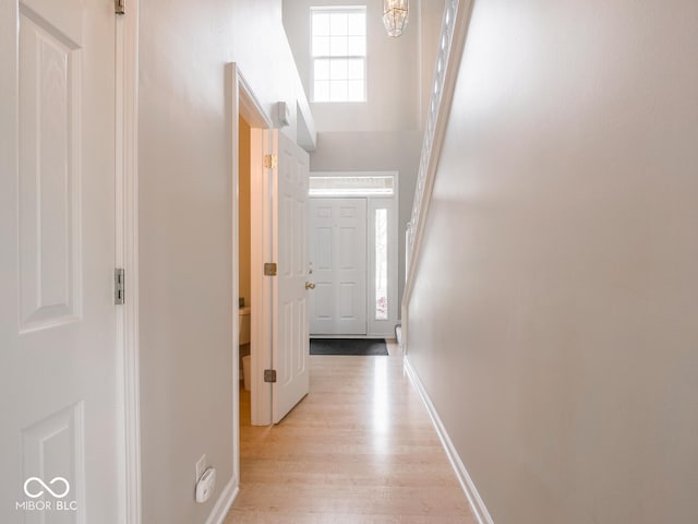 hallway featuring light wood-type flooring and baseboards