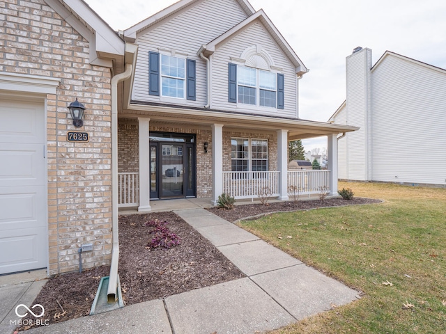 view of front of property featuring covered porch, brick siding, a front yard, and a garage