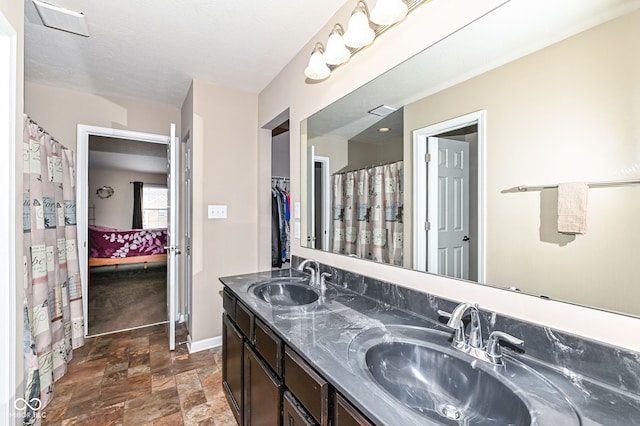 full bathroom with stone finish flooring, visible vents, a sink, and ensuite bath