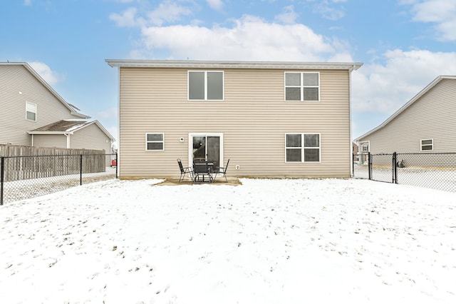 snow covered house with fence