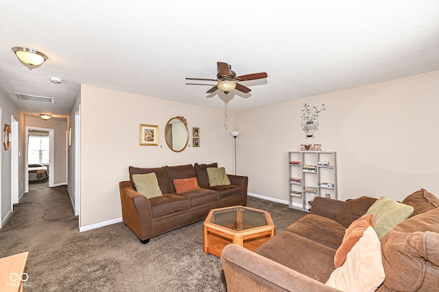 living room with baseboards, visible vents, dark carpet, and a ceiling fan