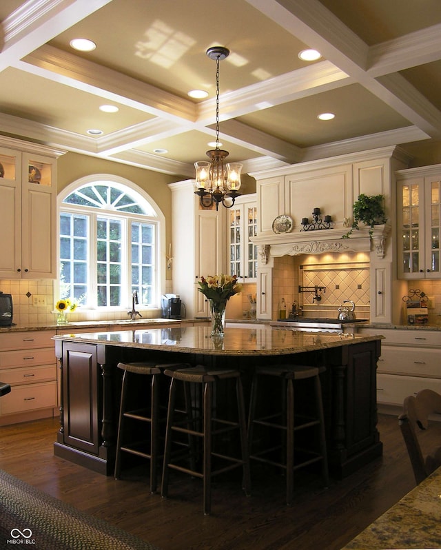 bar featuring hanging light fixtures, coffered ceiling, light stone countertops, and dark hardwood / wood-style flooring