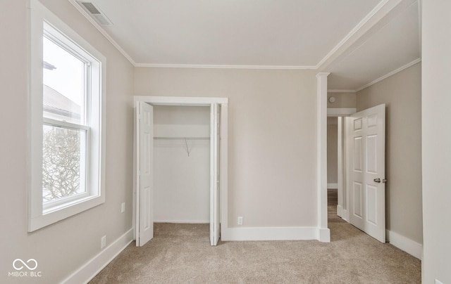 unfurnished bedroom featuring crown molding, light colored carpet, and a closet