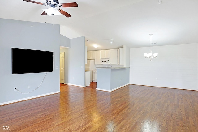 unfurnished living room featuring baseboards, vaulted ceiling, wood finished floors, and ceiling fan with notable chandelier