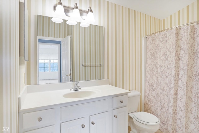 bathroom with a shower with shower curtain, vanity, toilet, and wallpapered walls