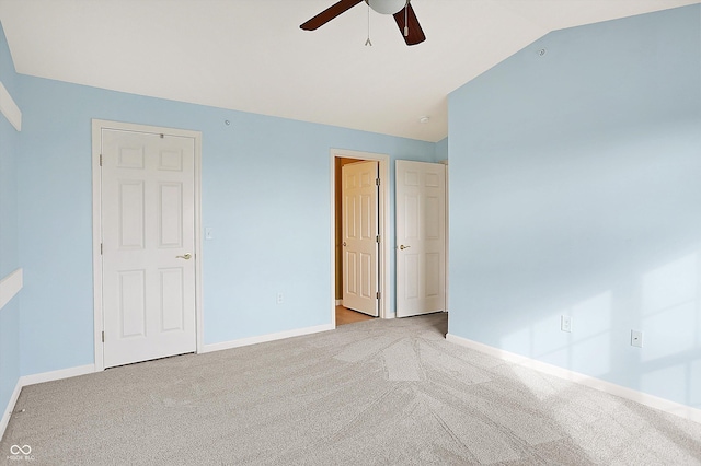 unfurnished bedroom with a ceiling fan, carpet flooring, vaulted ceiling, and baseboards