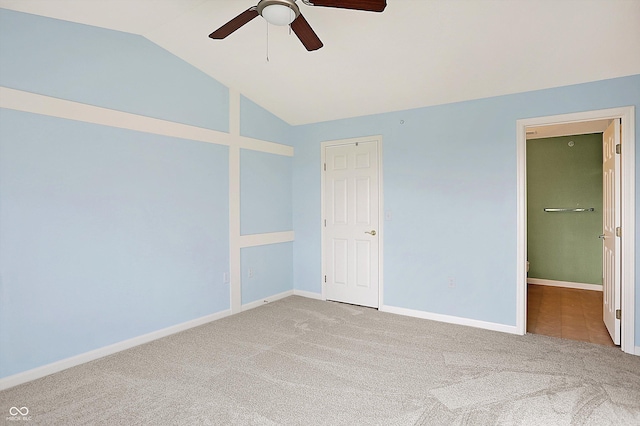 unfurnished bedroom featuring carpet flooring, vaulted ceiling, baseboards, and ceiling fan