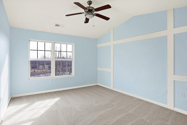 carpeted spare room with a ceiling fan, visible vents, vaulted ceiling, and baseboards