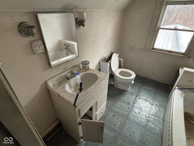 bathroom featuring vaulted ceiling, vanity, and toilet