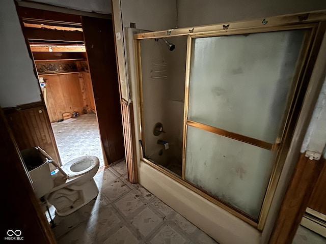 bathroom featuring a baseboard radiator, shower / bath combination with glass door, and toilet