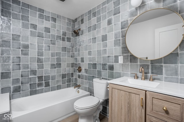 full bathroom with backsplash, toilet, tile walls, vanity, and tiled shower / bath combo