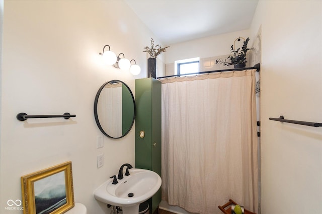 bathroom featuring curtained shower and a sink