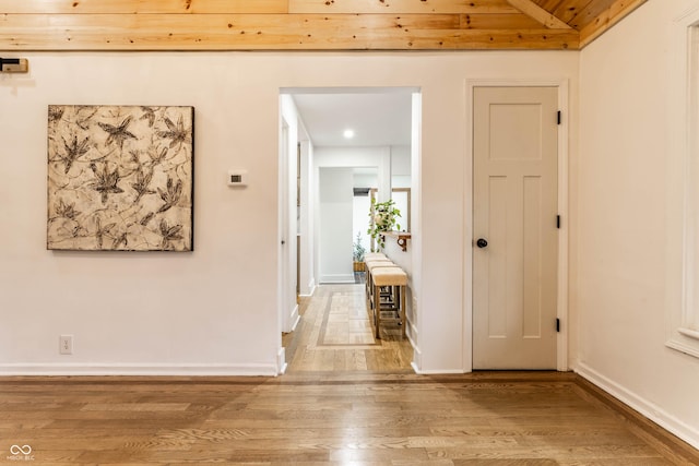 hall with lofted ceiling and light wood-type flooring