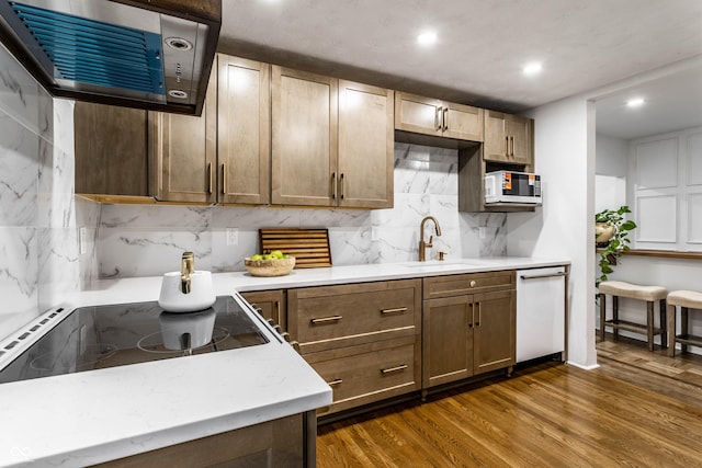 kitchen with dark wood-type flooring, sink, extractor fan, tasteful backsplash, and white appliances