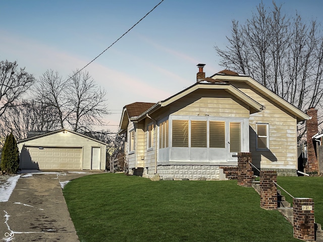 view of front facade featuring a garage, an outdoor structure, and a lawn