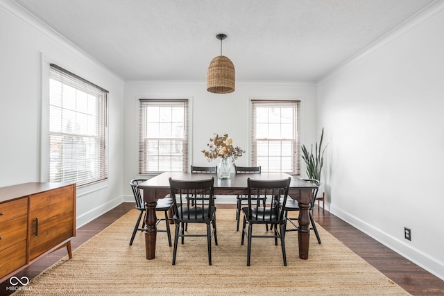 dining room featuring dark wood-style floors, ornamental molding, and a wealth of natural light