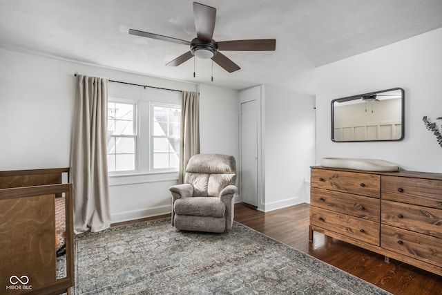 sitting room with wood finished floors, a ceiling fan, and baseboards