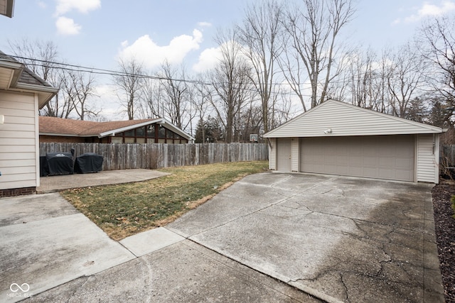 exterior space featuring a garage, fence, and an outdoor structure