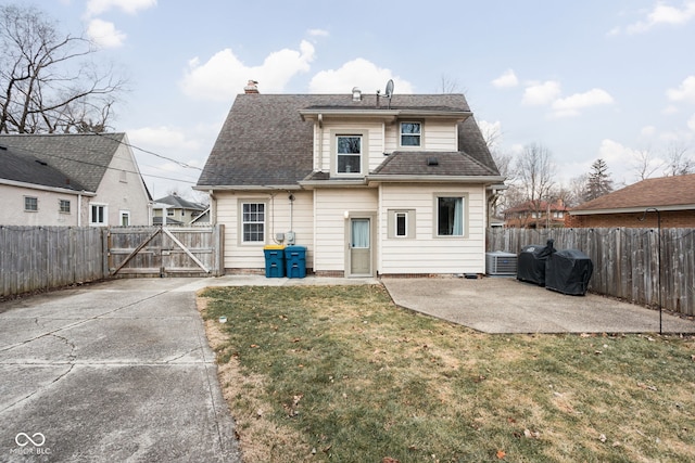 rear view of house featuring a yard, a patio, a gate, cooling unit, and a fenced backyard