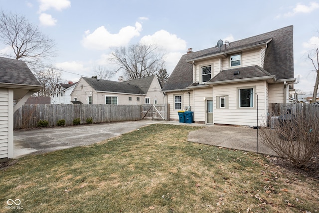 rear view of property with a yard, a patio area, fence, and a chimney