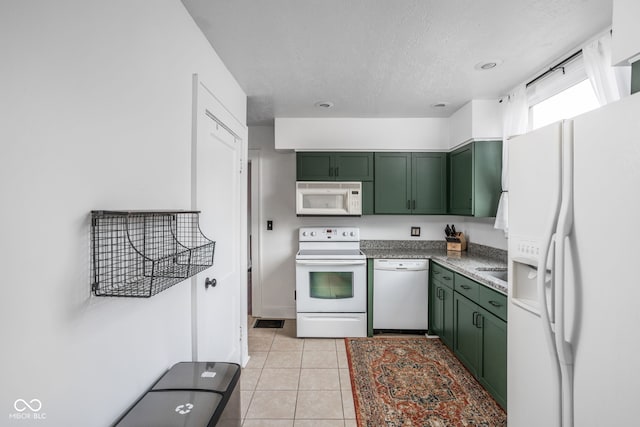 kitchen featuring white appliances, a textured ceiling, green cabinets, and light tile patterned floors