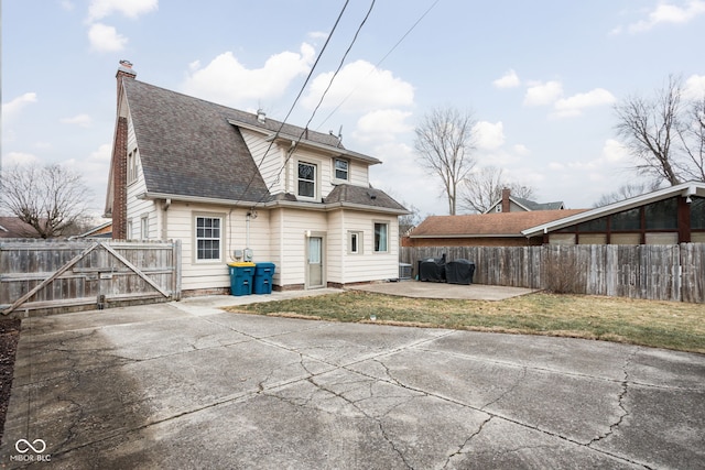 back of house with a patio area, a chimney, fence, and a yard