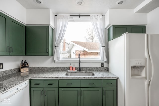 kitchen featuring white appliances, green cabinetry, and a sink