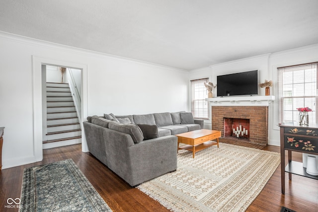 living area with stairs, ornamental molding, dark wood-type flooring, and a fireplace