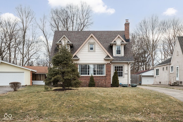 view of front of house featuring brick siding, a chimney, an outdoor structure, and a front yard