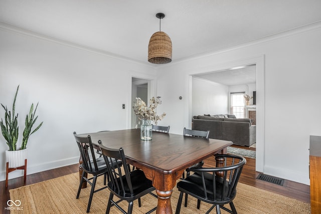 dining area featuring ornamental molding, wood finished floors, and baseboards