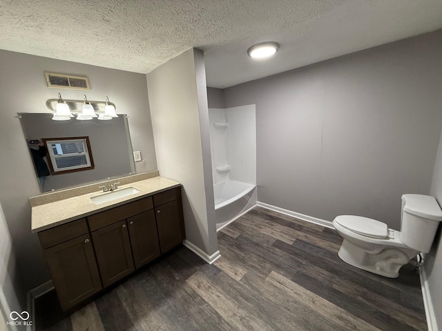 full bathroom featuring toilet, a textured ceiling, vanity, shower / washtub combination, and hardwood / wood-style floors