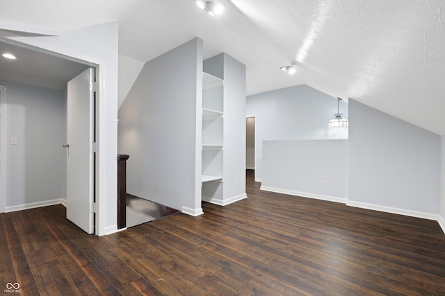 additional living space featuring dark hardwood / wood-style floors and vaulted ceiling