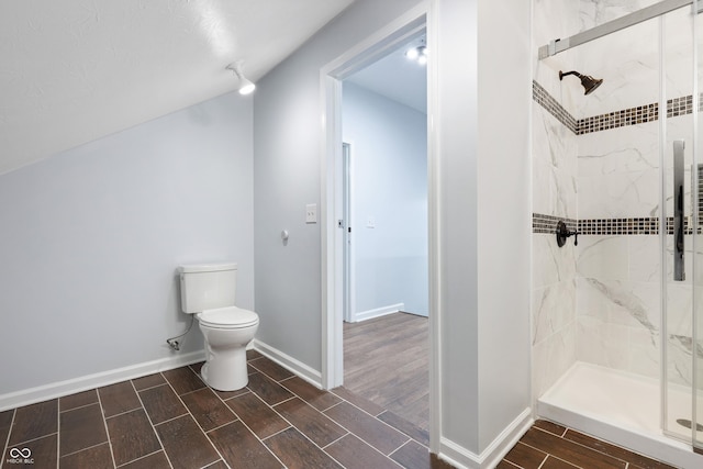 bathroom featuring toilet and a shower with shower door