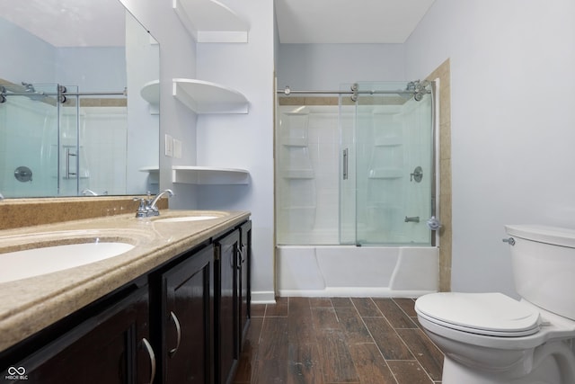 full bathroom with vanity, bath / shower combo with glass door, and toilet