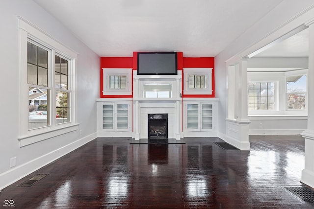 unfurnished living room featuring a wealth of natural light and wood-type flooring