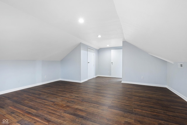 bonus room with dark wood-type flooring and vaulted ceiling