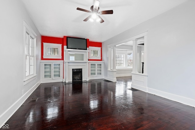 unfurnished living room featuring hardwood / wood-style floors, ceiling fan, and ornate columns