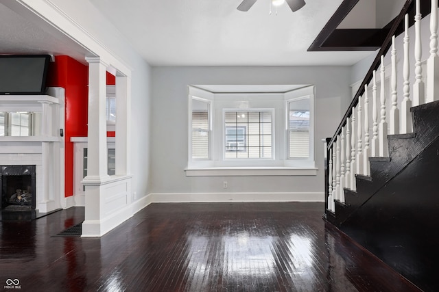 living room with ceiling fan, hardwood / wood-style floors, and ornate columns