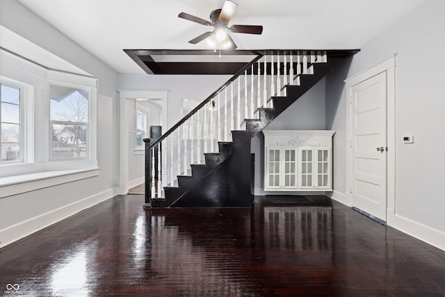 stairs with wood-type flooring and ceiling fan