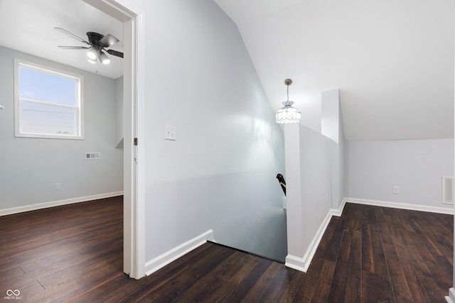 additional living space with ceiling fan with notable chandelier, vaulted ceiling, and dark hardwood / wood-style floors